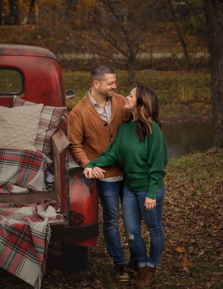 Couple in front of red truck for photography mini sessions in Hartland, MI