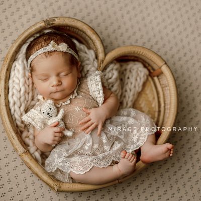 newborn girl in heart prop in studio in brighton, mi