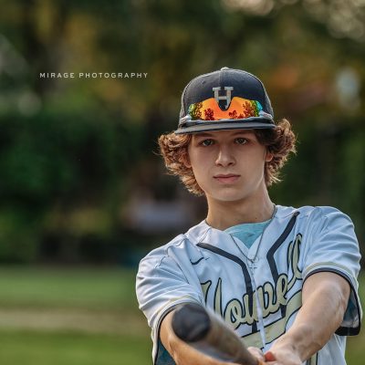 senior boy with baseball bat on field