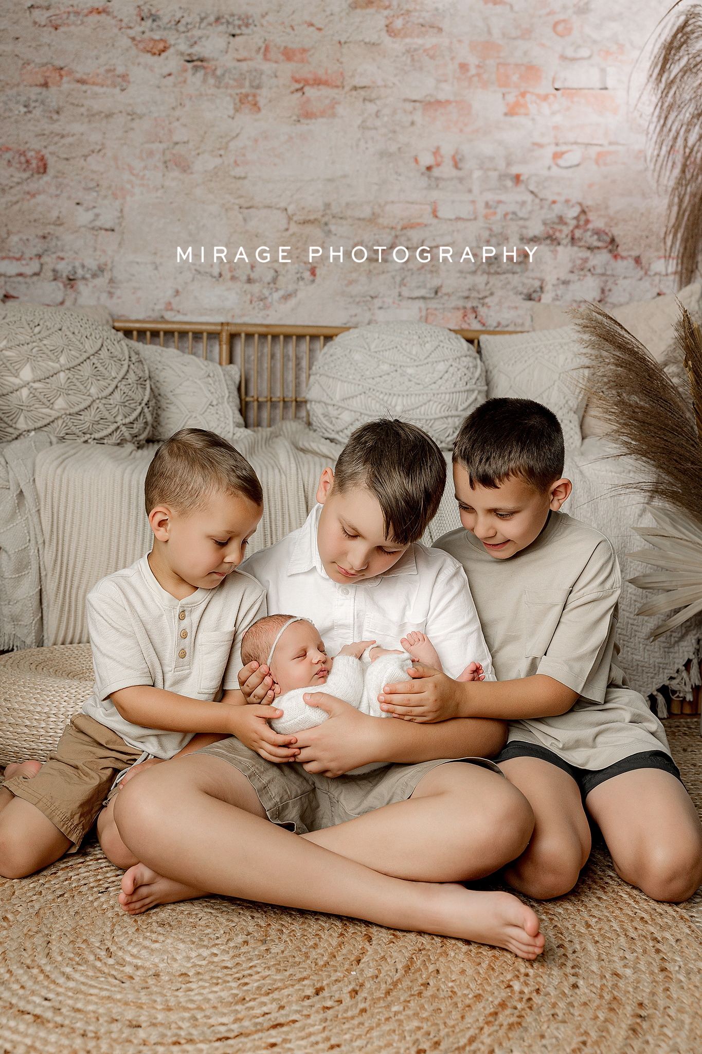 Brother and sister in coordinated neutral outfits during a newborn session.