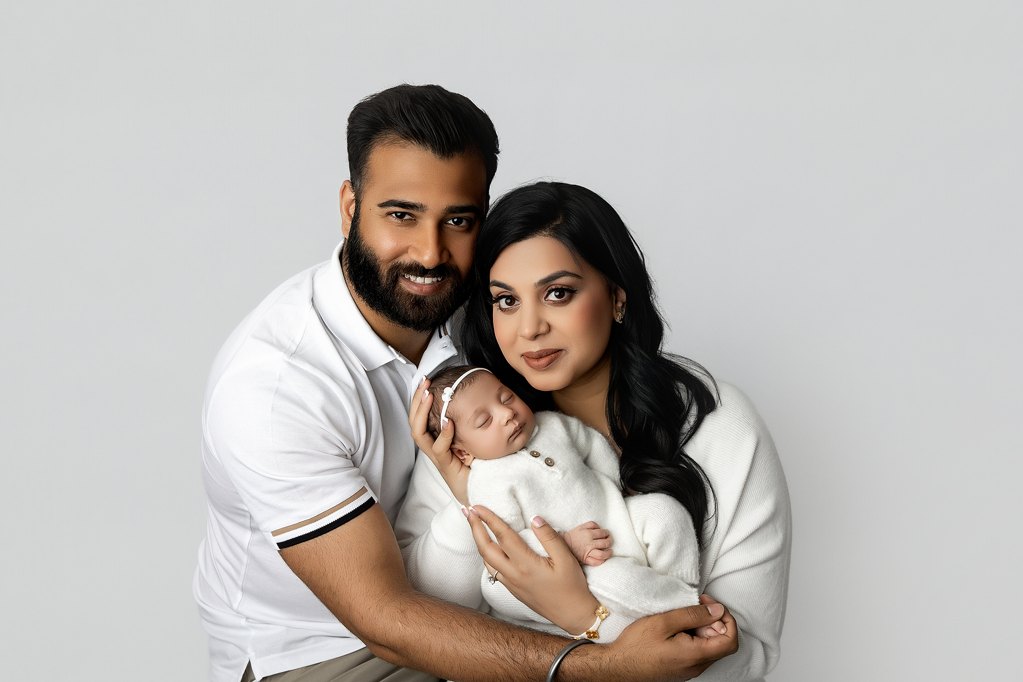 Parent holding newborn during a modern studio portrait at Mirage Photography