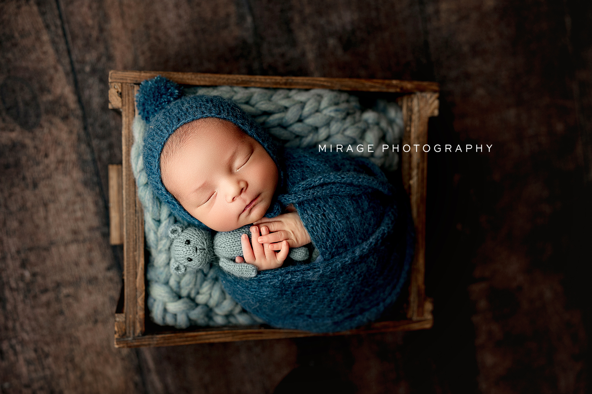 Newborn baby wrapped in neutral colors during studio photography session in Fowlerville Michigan